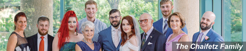 11 family members all dressed up and smiling at the camera at a wedding